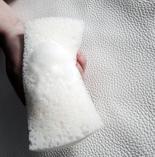 Pflegemittelauftrag auf Schwamm. Reinigung mit einem Schwamm, Oflegemittelauftrag.